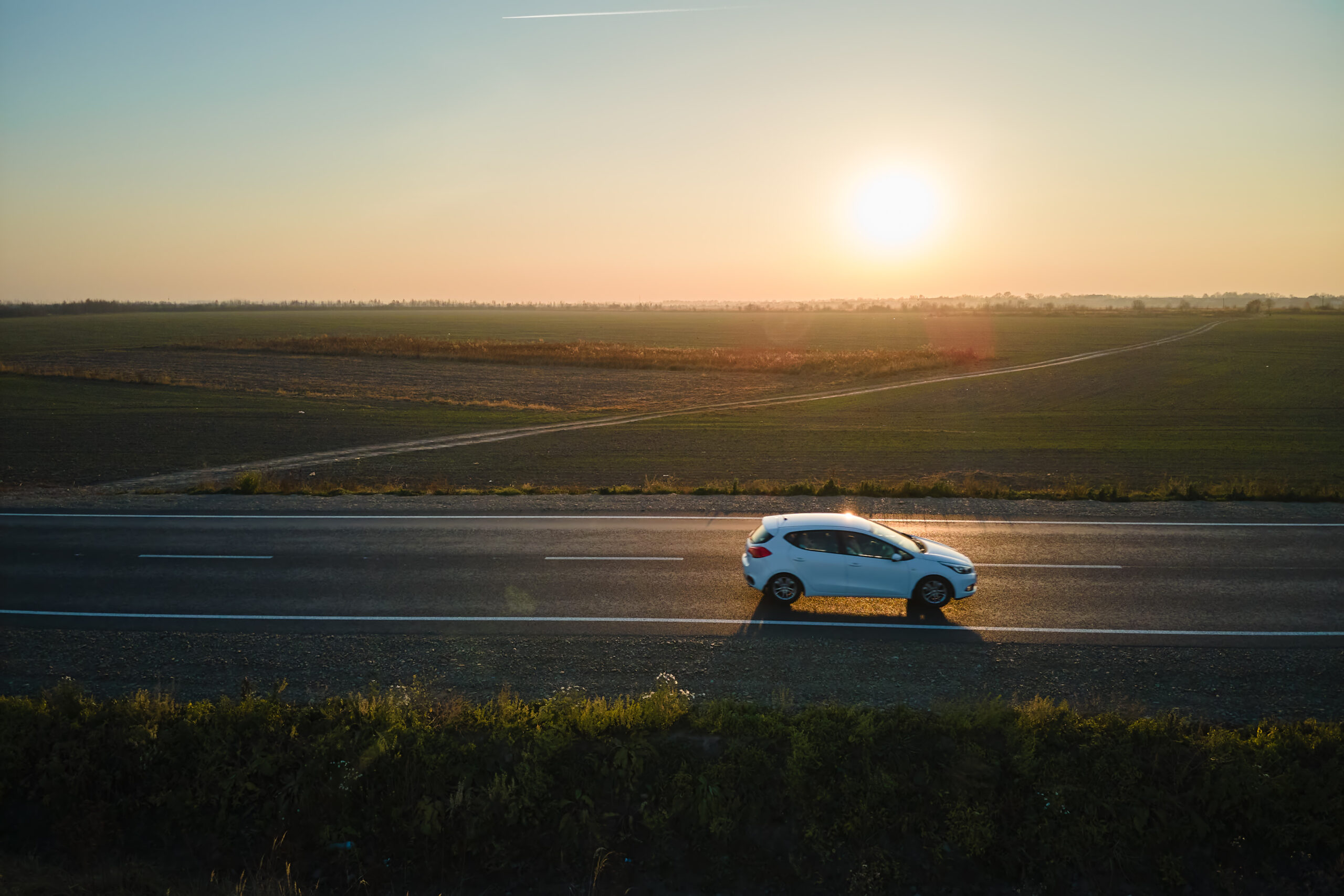 aerial view of intercity road with blurred fast driving environment friendly electric car at sunset. top view from drone of highway traffic in evening